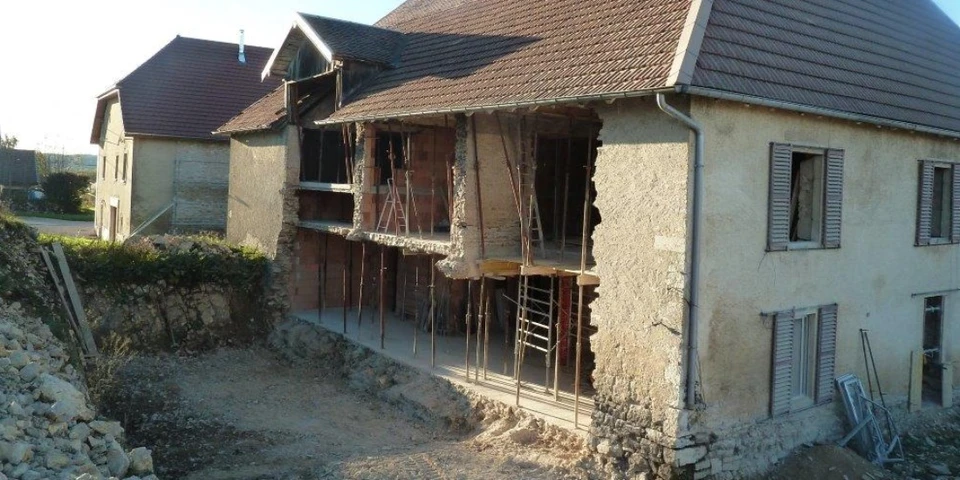 Ouvrier de construction dans le seau d'élévateur de la restauration et de la réparation de la façade historique du bâtiment