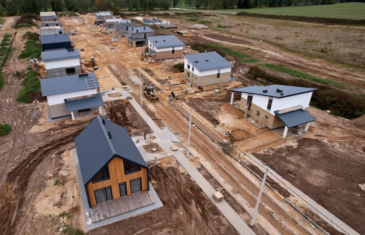 Chantier de construction résidentielle en cours avec plusieurs maisons individuelles à différents stades d'avancement