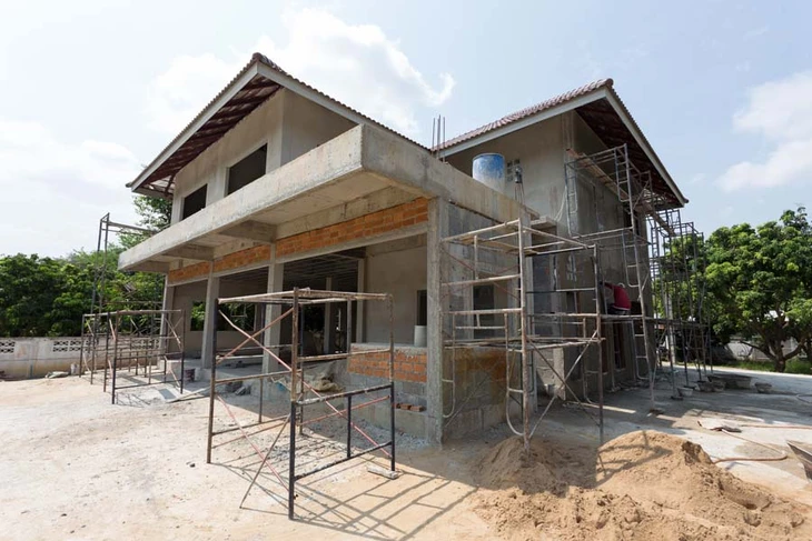 Chantier de construction résidentielle en cours, maison individuelle à deux niveaux avec échafaudages métalliques