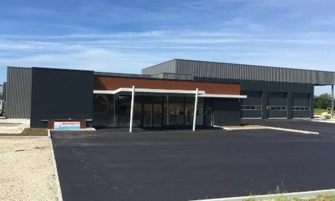 Façade extérieure d'une maison en pierre naturelle avec escalier menant à une porte d'entrée en bois